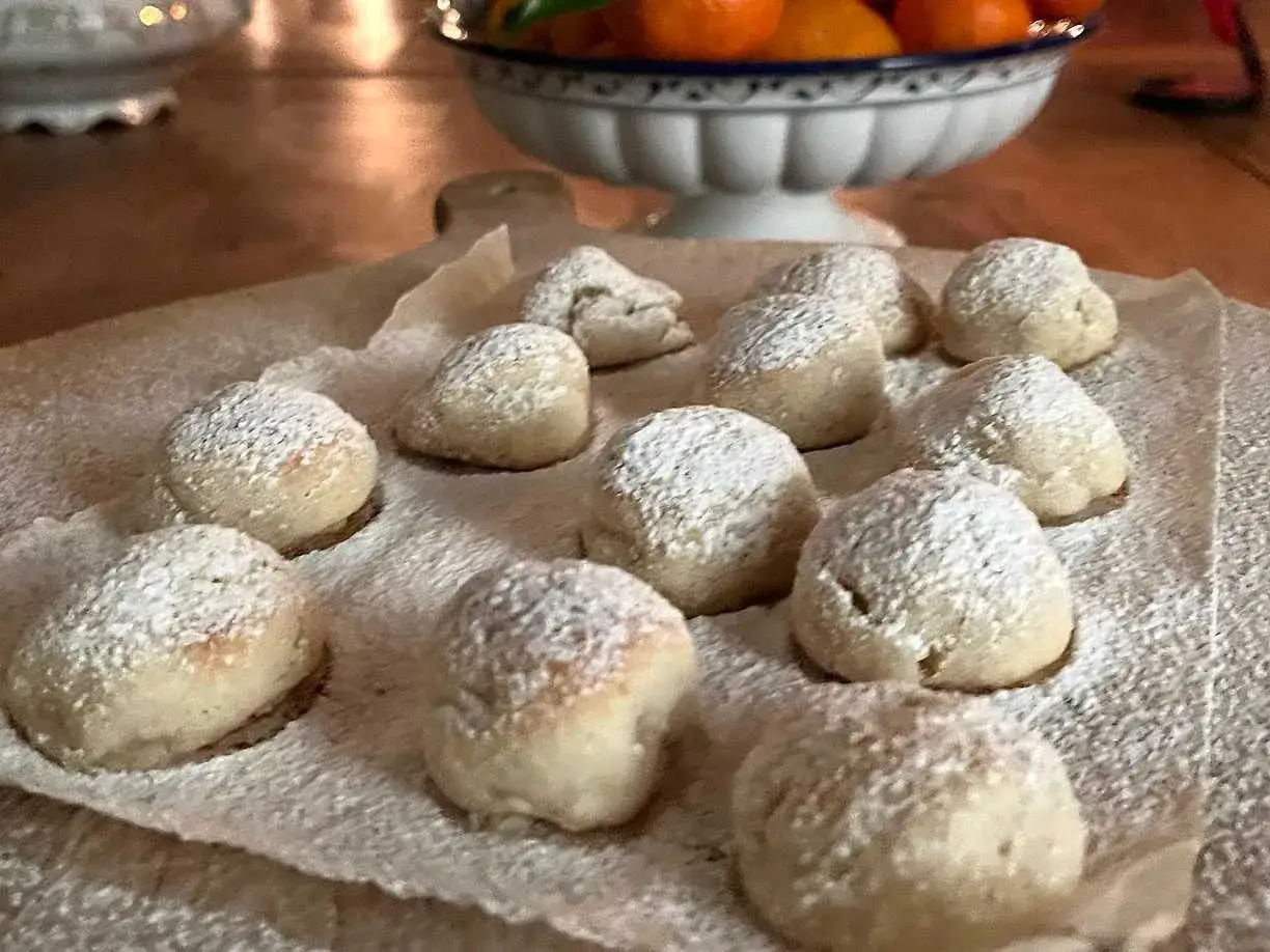 Sm&aring;, pudrade bakverk som p&aring;minner om torta caprese, ligger p&aring; bakpl&aring;tspapper.