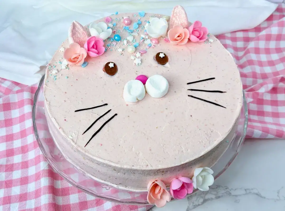 Ein süßer Geburtstagskuchen für Kinder, dekoriert als Katzen-Gesicht mit Marshmallows, Schokoladenaugen und bunten Streuseln.