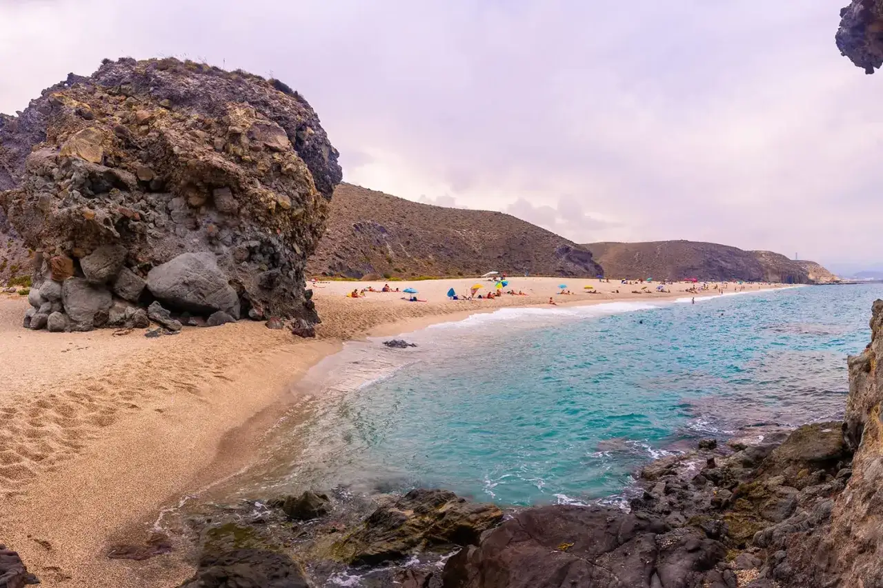 Piękna plaża w Cabo de Gata z turkusową wodą, piaszczystym brzegiem i skalistymi formacjami.