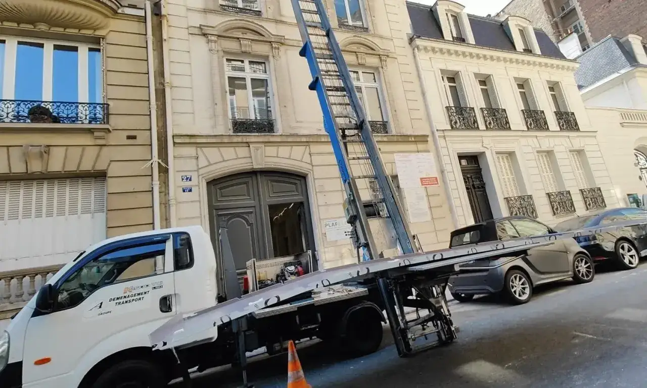 Camion de déménagement avec monte-meubles devant un immeuble parisien. Une nouvelle aventure commence avec ce déménagement à Paris.