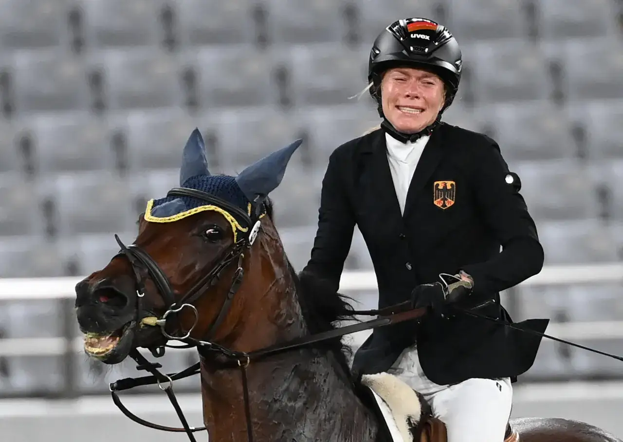 Une cavali&egrave;re allemande en plein effort lors de l'&eacute;preuve d'&eacute;quitation du pentathlon moderne. Son visage exprime la concentration intense.