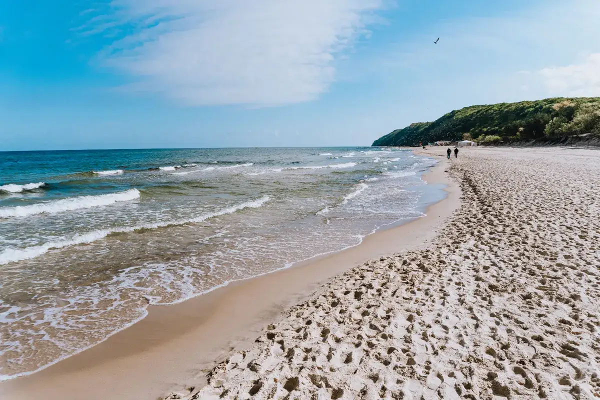 Piękna plaża, gdzie nad morze znajdziesz mnóstwo atrakcji. Spacerowicze cieszą się słońcem i szumem fal.
