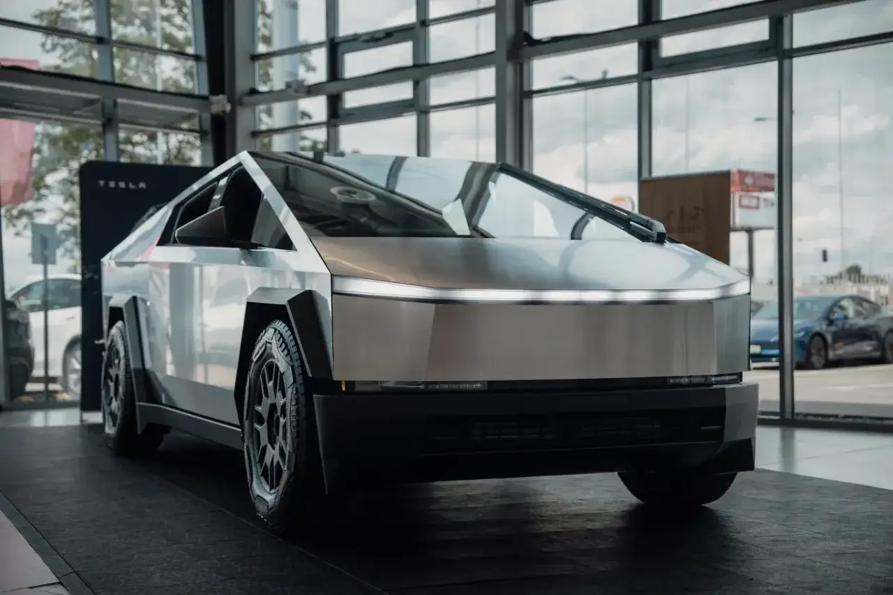 Futurystyczny Cybertruck Tesli prezentuje swoje ostre linie i metaliczne nadwozie w salonie.