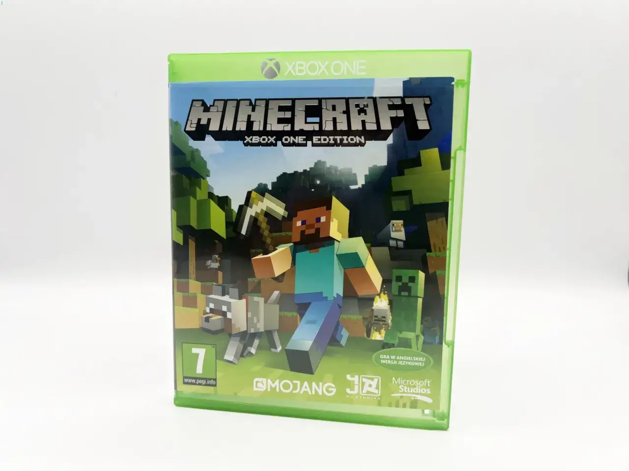 Minecraft na Xbox One to świetna gra dla dzieci. Na okładce Steve z kilofem, pies, owca i creeper w blokowym świecie.
