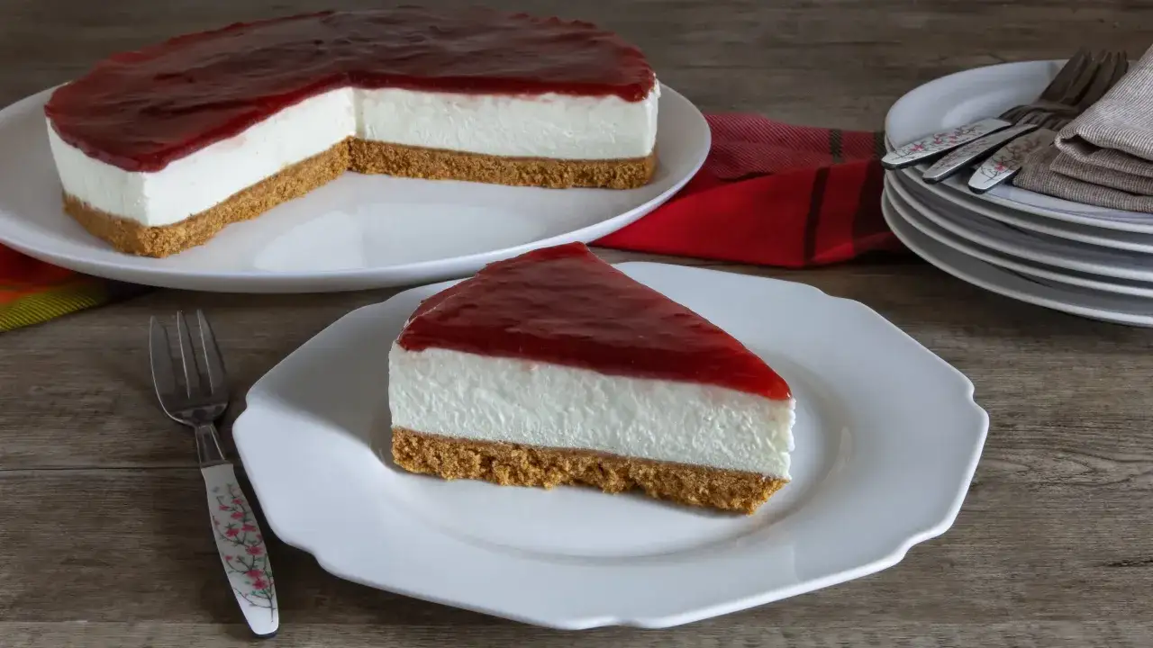 Cheesecake ricetta: una fetta di torta cremosa con base croccante e copertura di fragole, pronta per essere gustata.