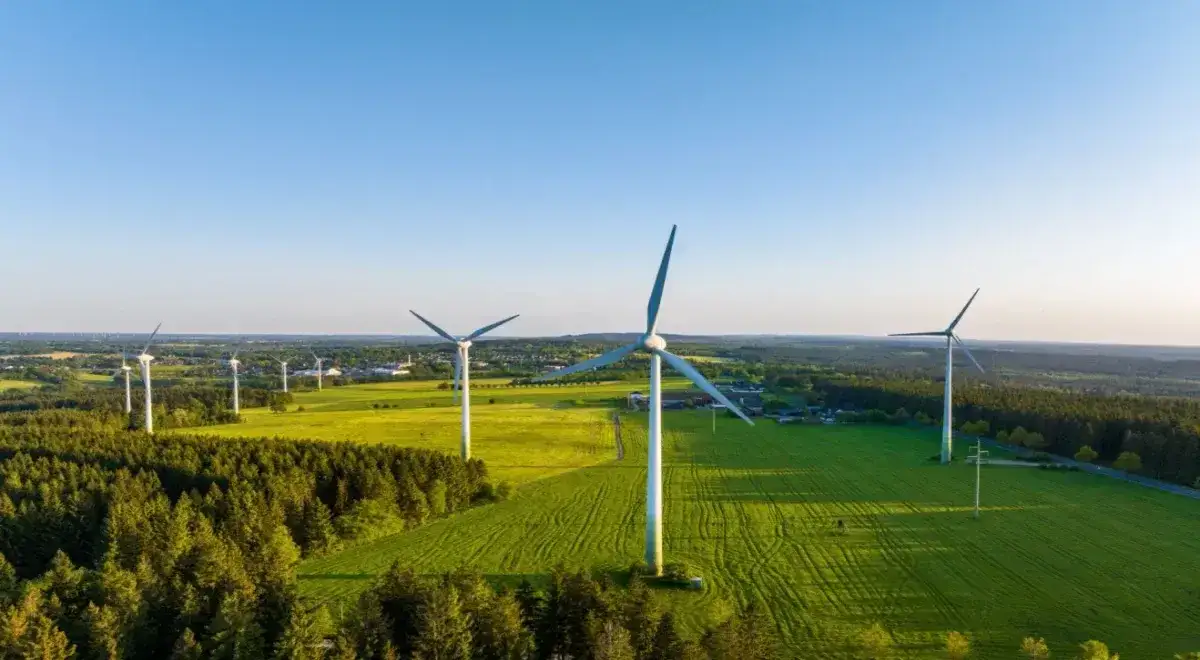 Wiatraki na zielonym polu, symbol przyszłości energetyki odnawialnej. Kiedy wejdzie w życie ustawa o OZE, takich widoków będzie więcej.