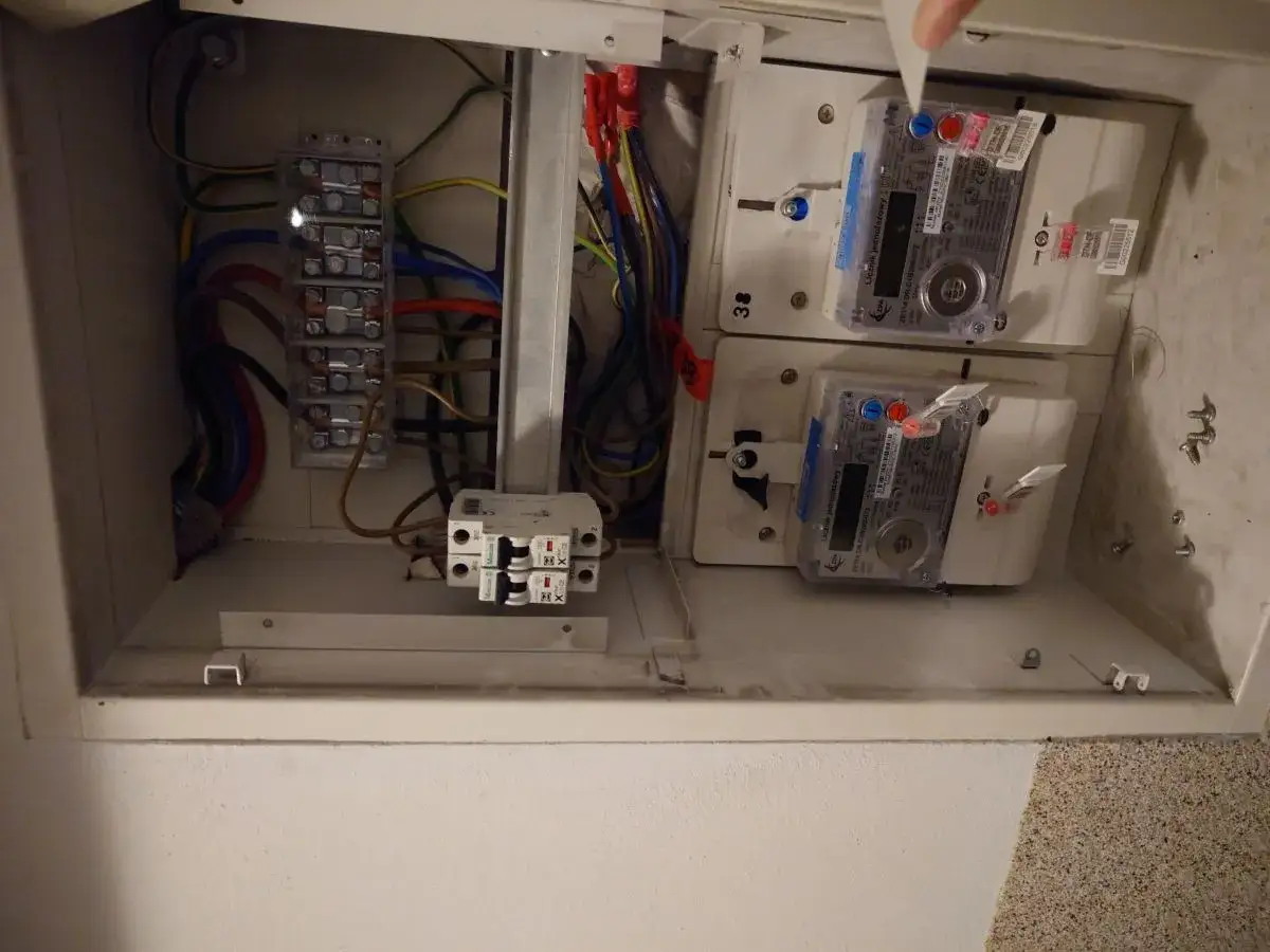 W skrzynce elektrycznej widoczne są liczniki energii elektrycznej oraz zabezpieczenie przedlicznikowe.