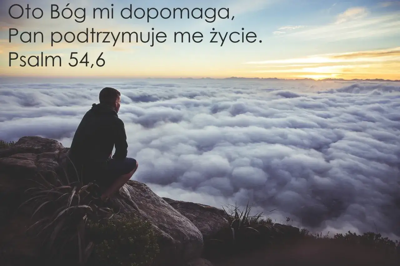 Mężczyzna siedzi na skale, patrząc na morze chmur. Cytat z Psalmu 56: