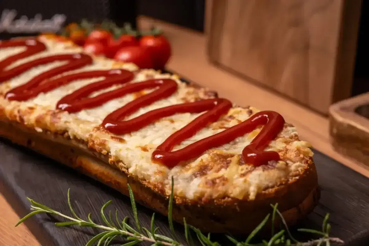 Chrupiące zapiekanki z airfryer, polane keczupem i posypane serem, wyglądają pysznie. Idealne na szybką przekąskę.