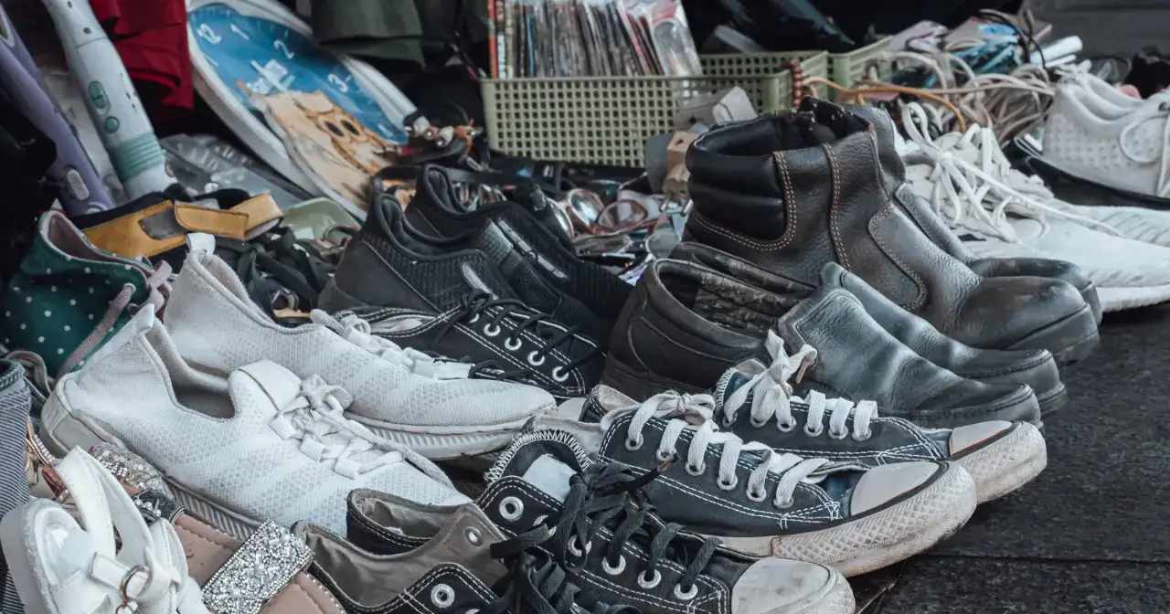Różne rodzaje obuwia, od sportowych sneakersów po skórzane buty, czekają na drugie życie. Zastanawiasz się, gdzie wyrzucać stare buty? Recykling to dobry pomysł!