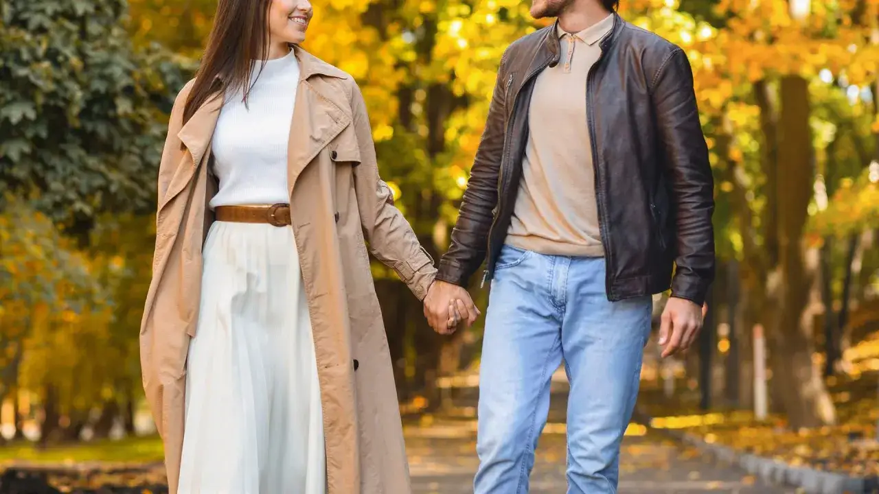 Coppia mano nella mano in un parco autunnale, un'immagine che cattura il vero amore significato.