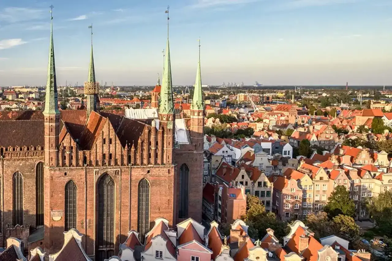 Widok na Bazylikę Mariacką i urokliwe kamieniczki, które tworzą malownicze stare miasto Gdańsk.