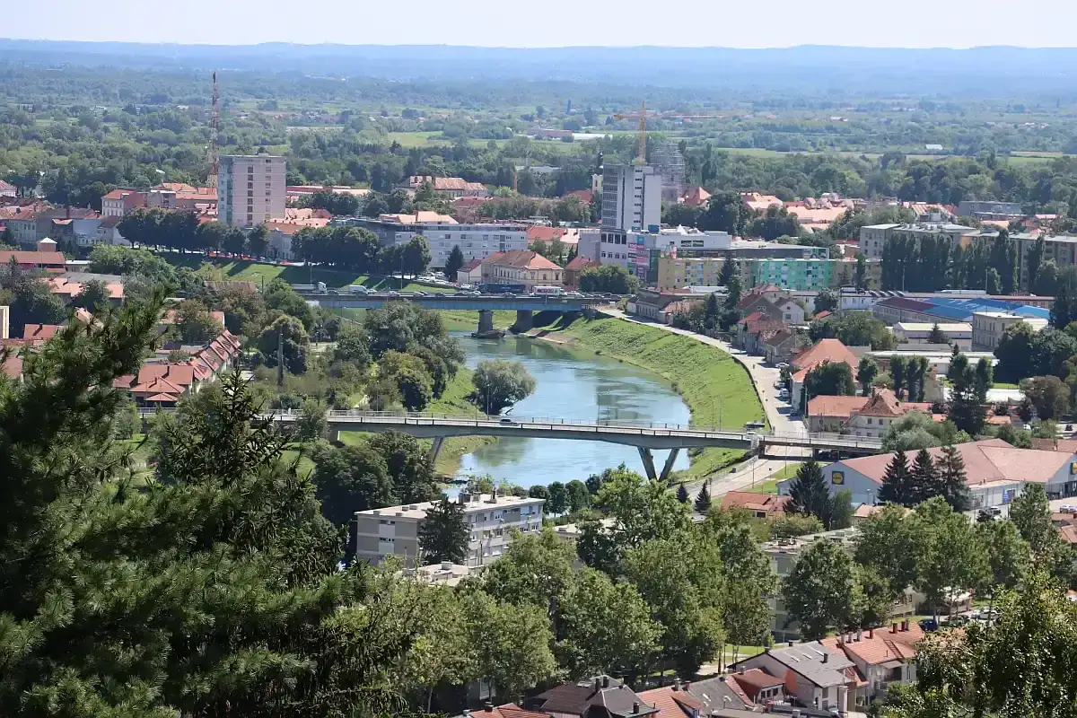 Widok na miasto Karlovac w Chorwacji z rzeką przepływającą przez środek i mostami.
