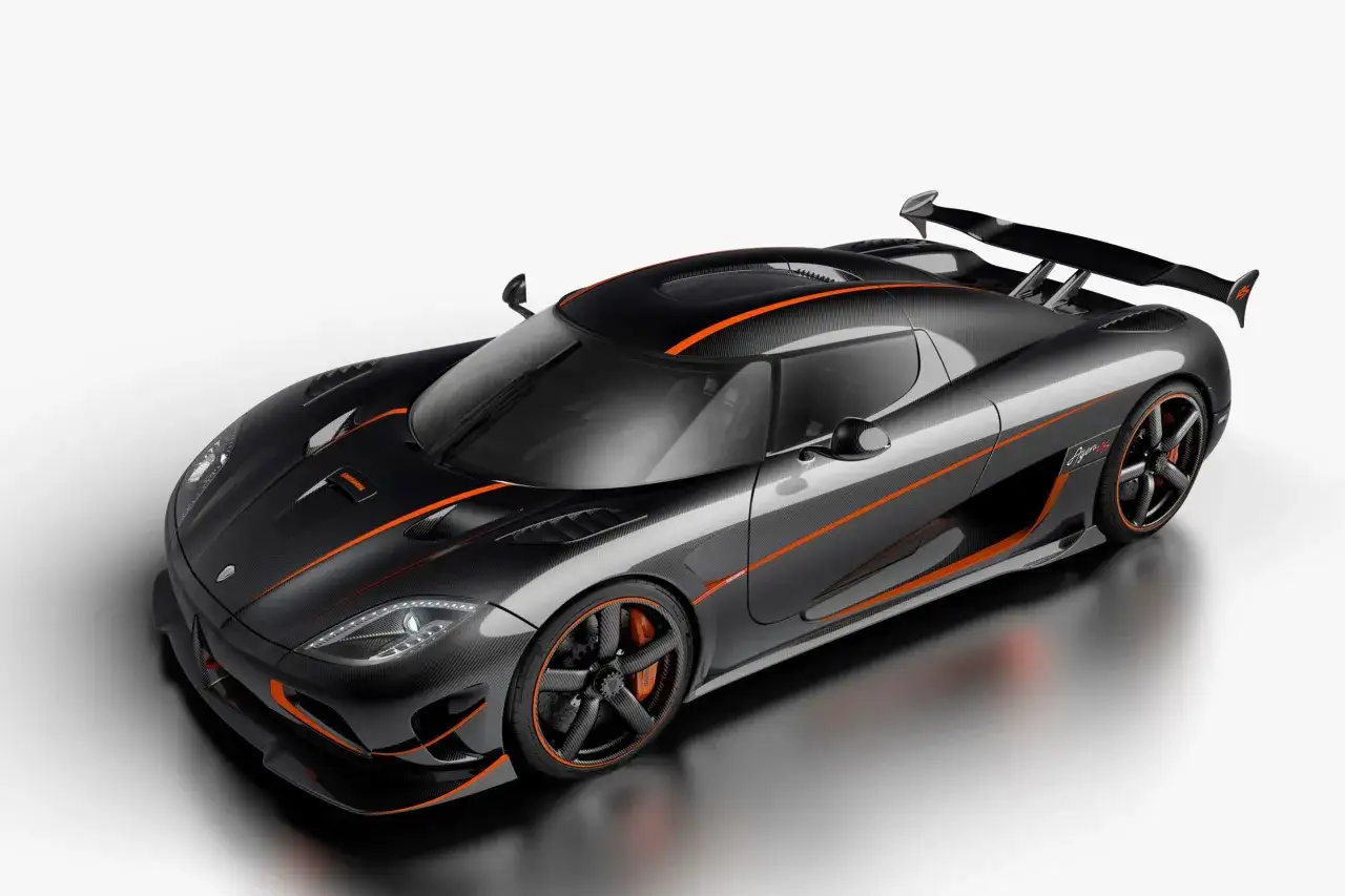 Czarny Koenigsegg Agera RS z pomarańczowymi akcentami, prezentujący swoje karbonowe nadwozie i aerodynamiczne detale.