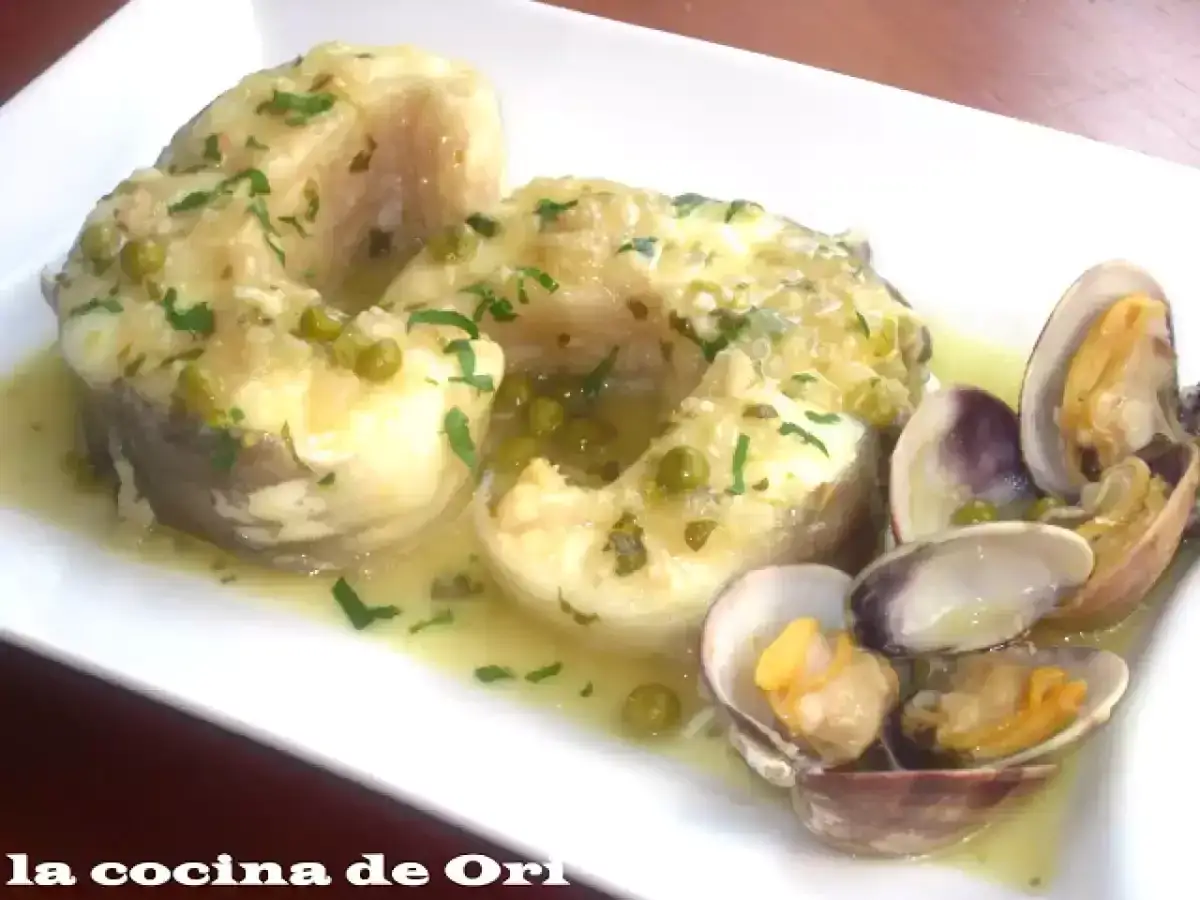 Congrio en salsa verde con guisantes y almejas, un plato delicioso y lleno de sabor marino.