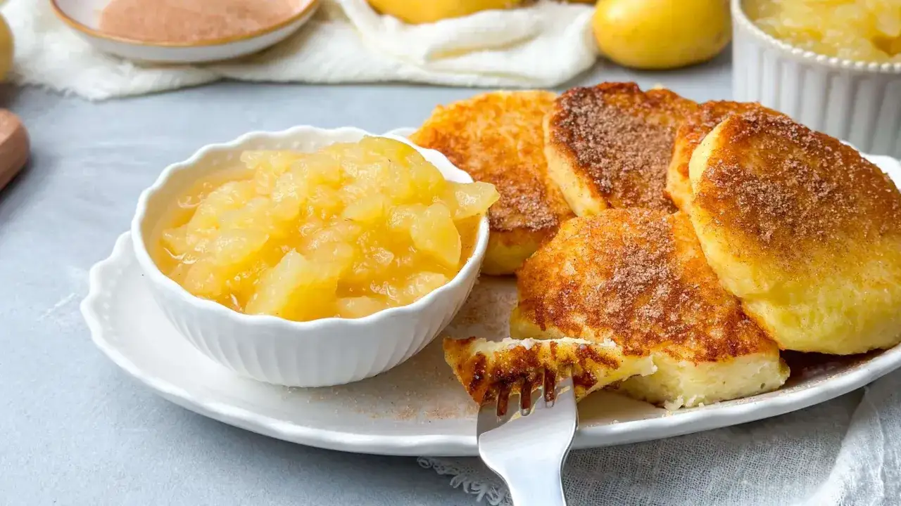 Quarkkeulchen ohne Kartoffeln, goldbraun gebraten und mit Zimt-Zucker bestreut, serviert mit Apfelmus. Ein Genuss!