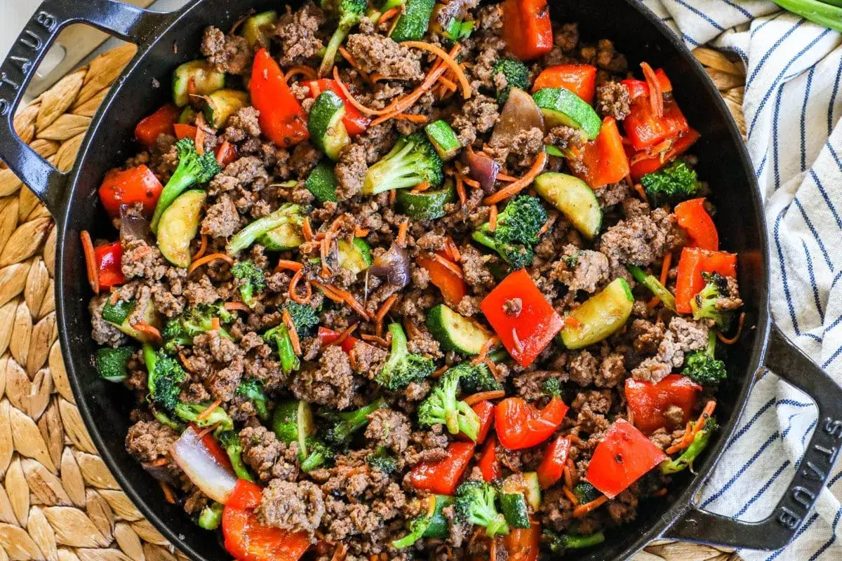Herzhafte hackfleisch gerichte mit buntem Gem&uuml;se wie Brokkoli, Paprika und Zucchini in einer Gusseisenpfanne.