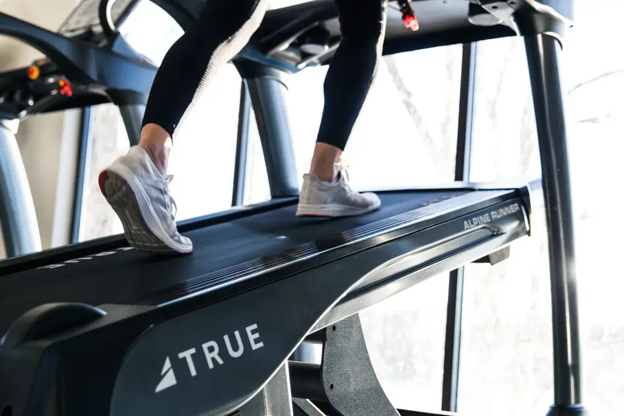 Beine in Laufschuhen absolvieren ein intensives Laufband Training.