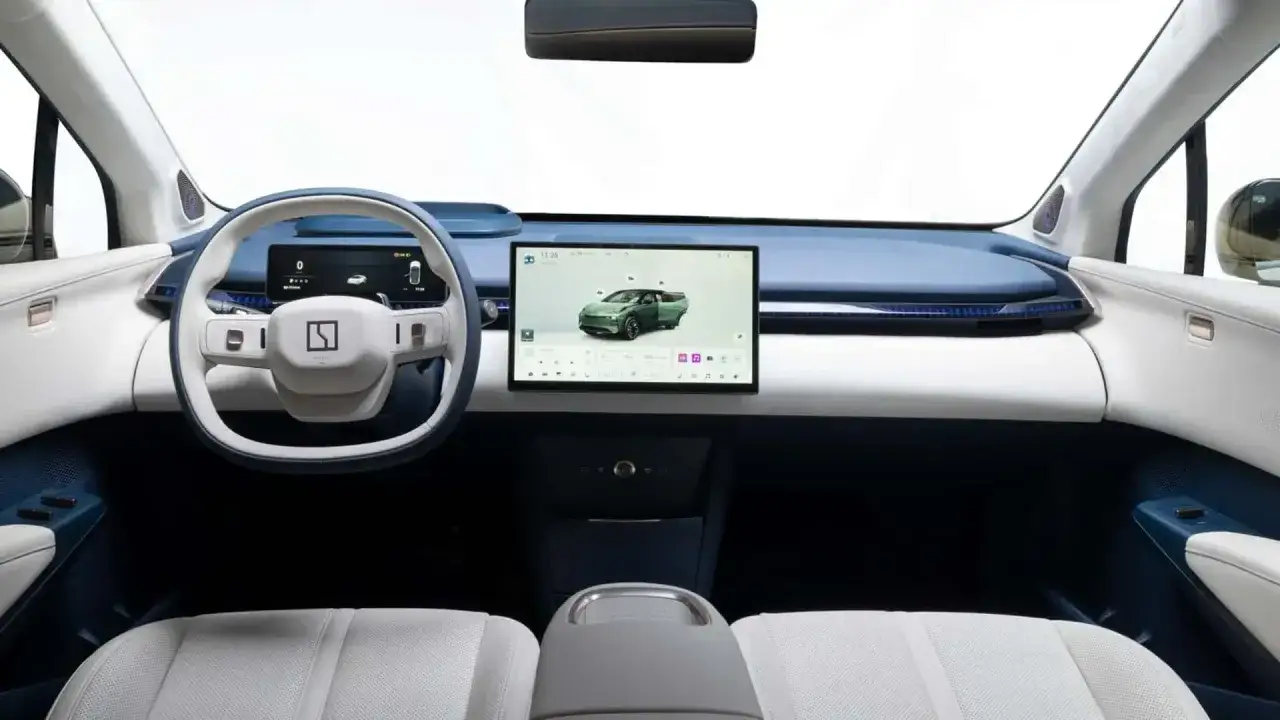 Interior del Zeekr X con pantalla táctil central, volante moderno y asientos blancos y azules.