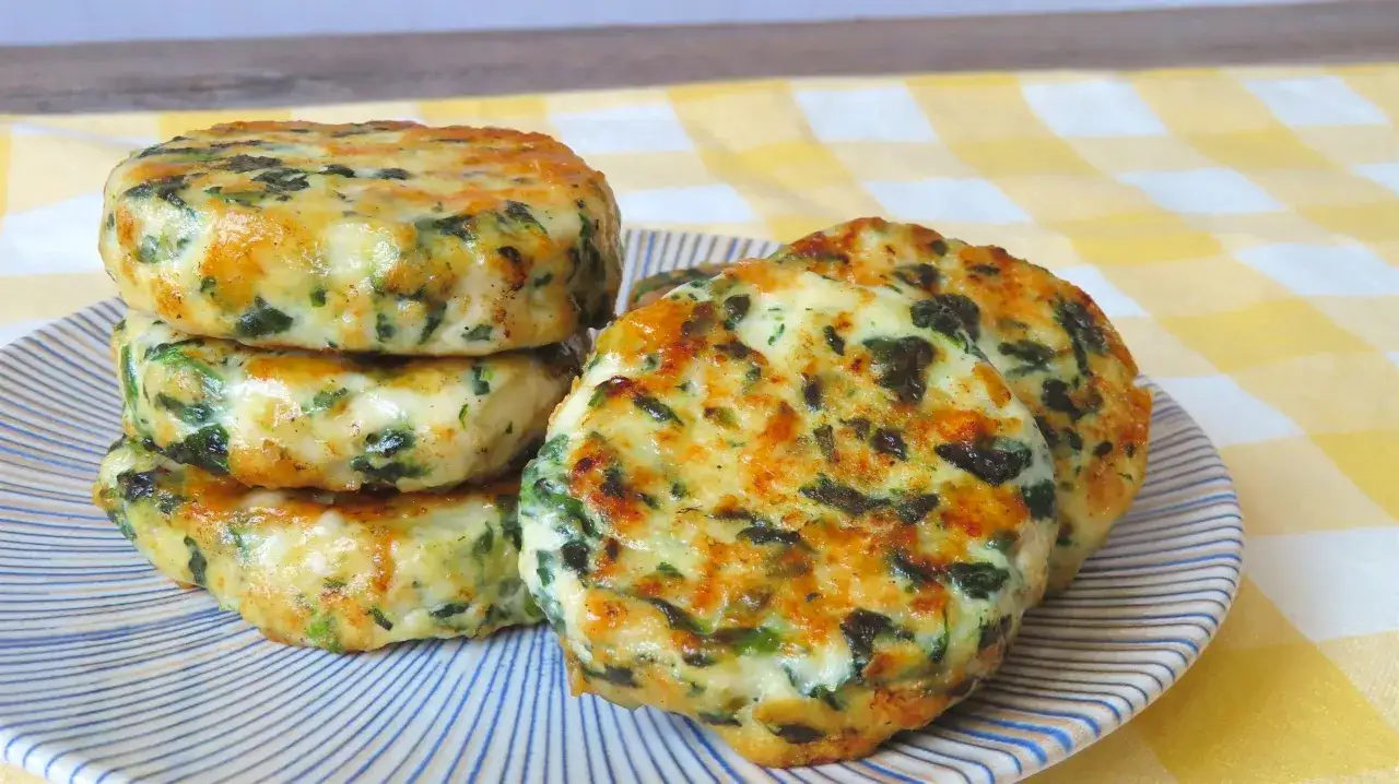 Apiladas y doradas, estas hamburguesas de pollo con espinacas lucen deliciosas en un plato rayado.