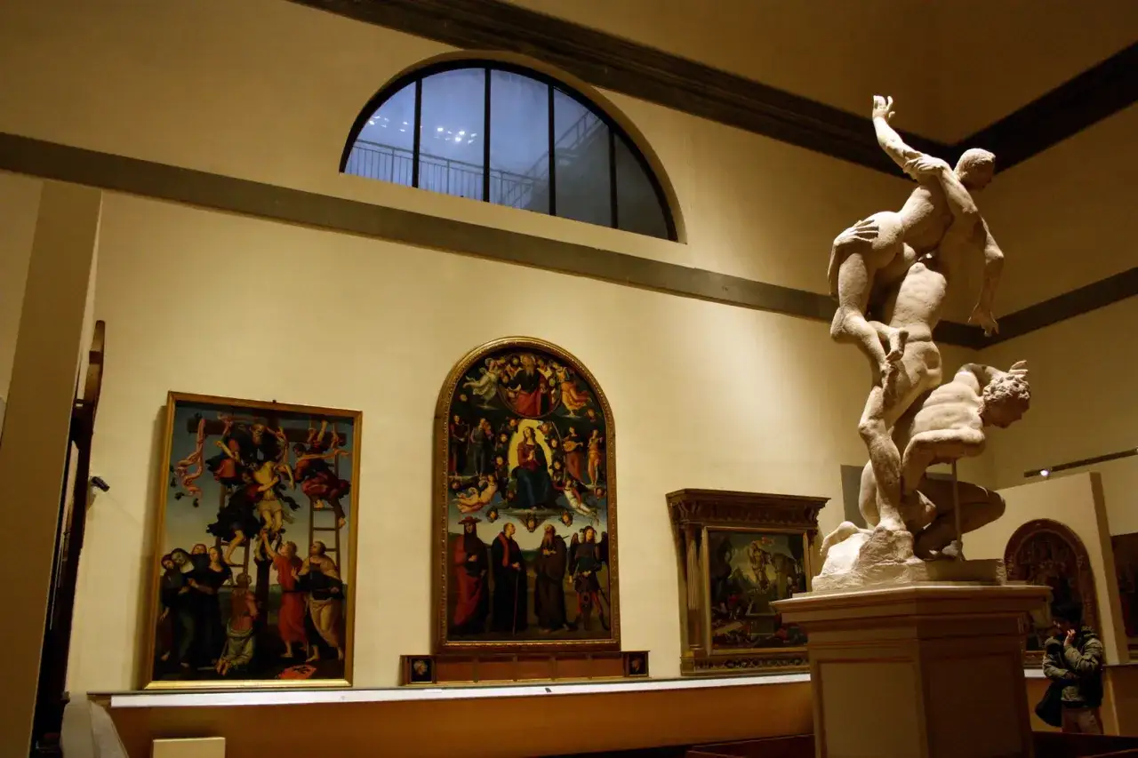 Scultura di Ercole e Caco nella **Gallerie dell'Accademia, Firenze**, con dipinti alle pareti.