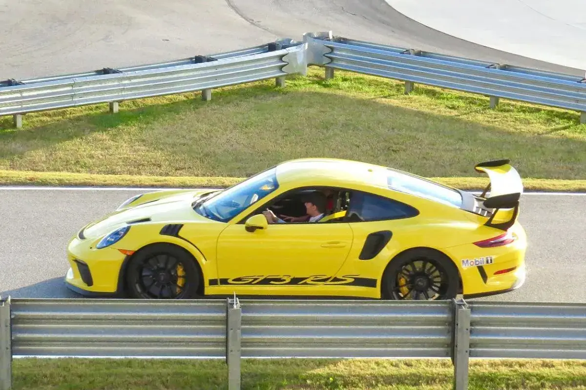 Gelber Porsche GT3 Rennwagen auf der Strecke, bereit f&uuml;r H&ouml;chstgeschwindigkeiten.