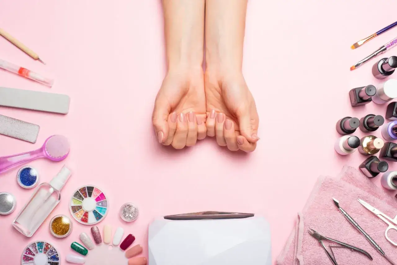 Domowe sposoby na bardzo zniszczone paznokcie: narzędzia do manicure, lakiery, lampa UV i zadbane dłonie.