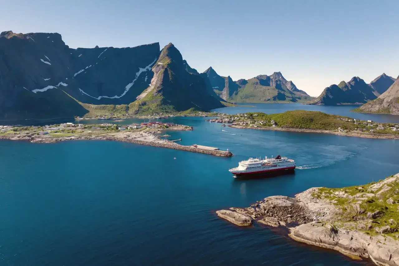 En kryssning till Lofoten bjuder på dramatiska berg, charmiga byar och ett fartyg som glider fram på det blå vattnet.