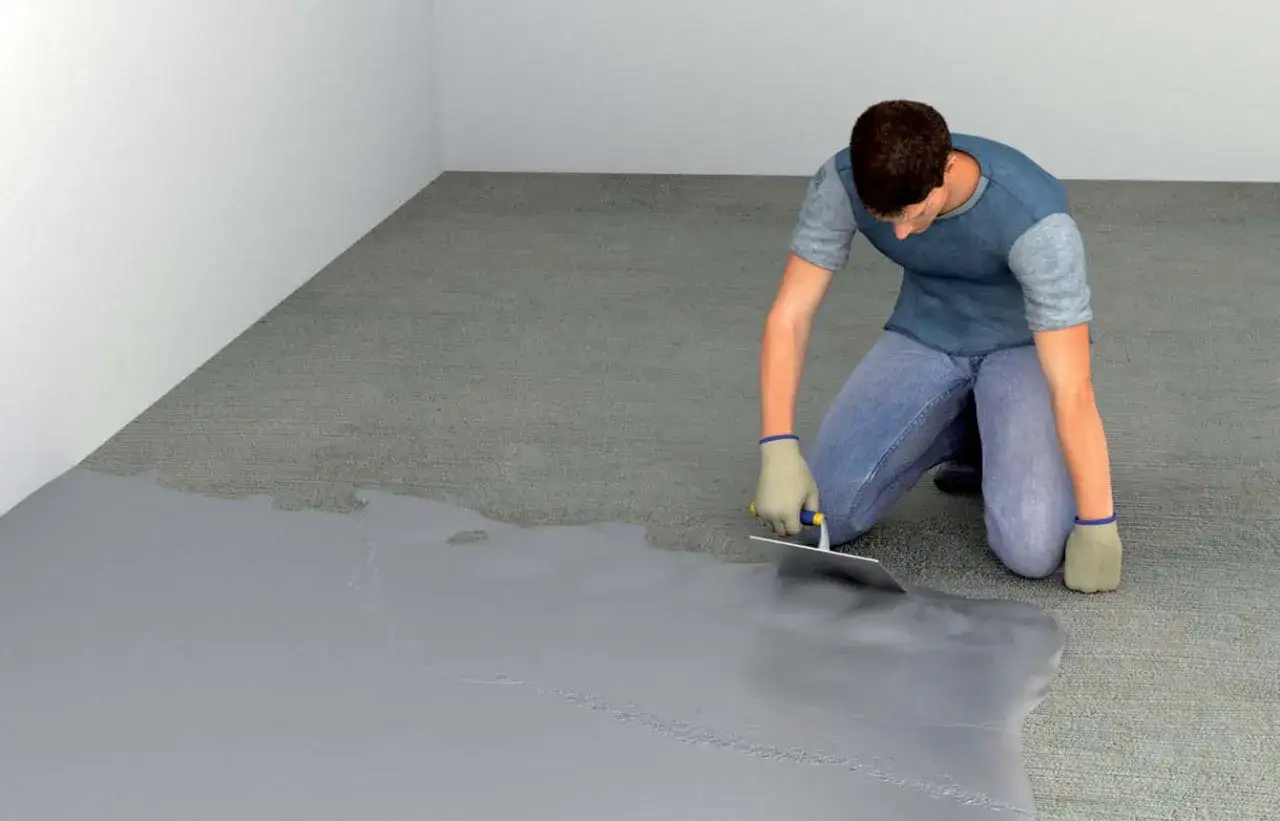 Application d'un rev&ecirc;tement gris sur un sol, transformant un espace en un **b&eacute;ton cir&eacute; garage** moderne et r&eacute;sistant.