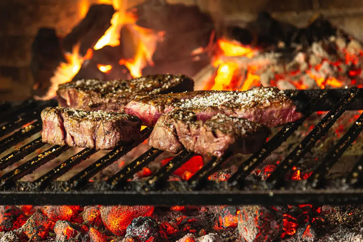 Saftiges Rinderfilet grillen über glühender Kohle. Die Steaks sind mit grobem Salz bestreut und entwickeln eine köstliche Kruste.