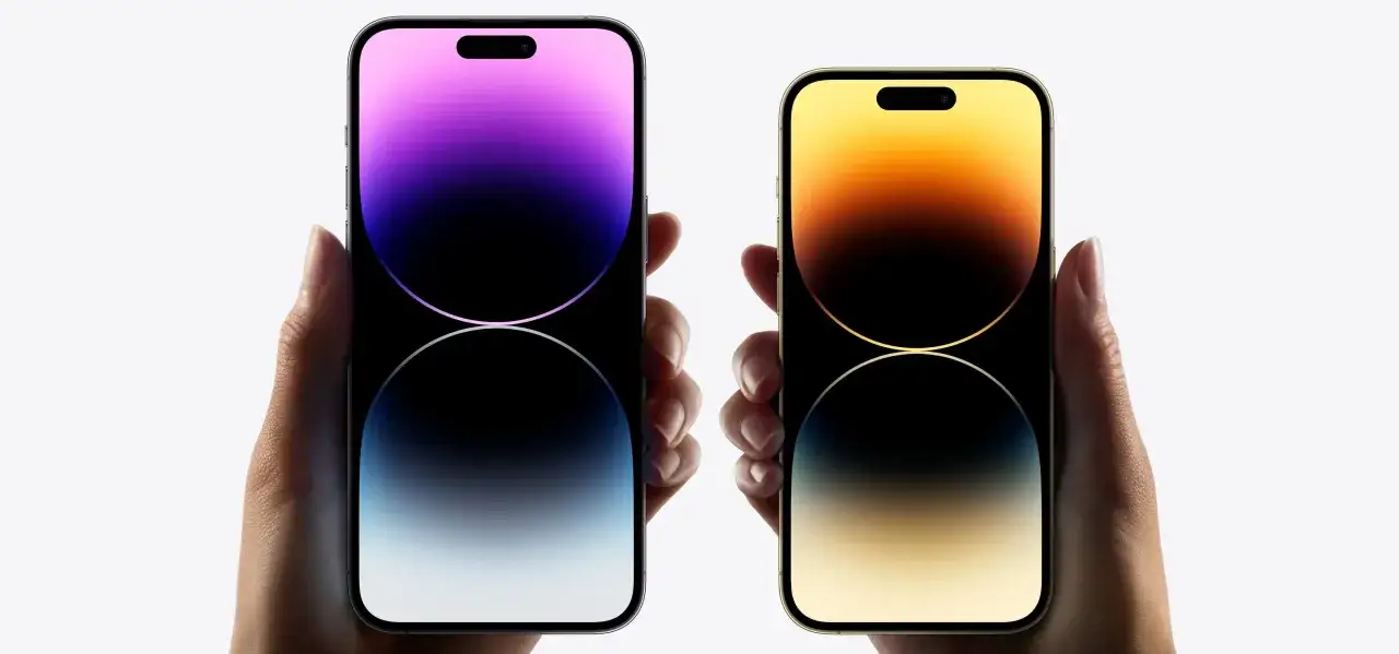 Dwie dłonie trzymają iPhone'y 14 Pro, prezentując ich wymiary i elegancki design.