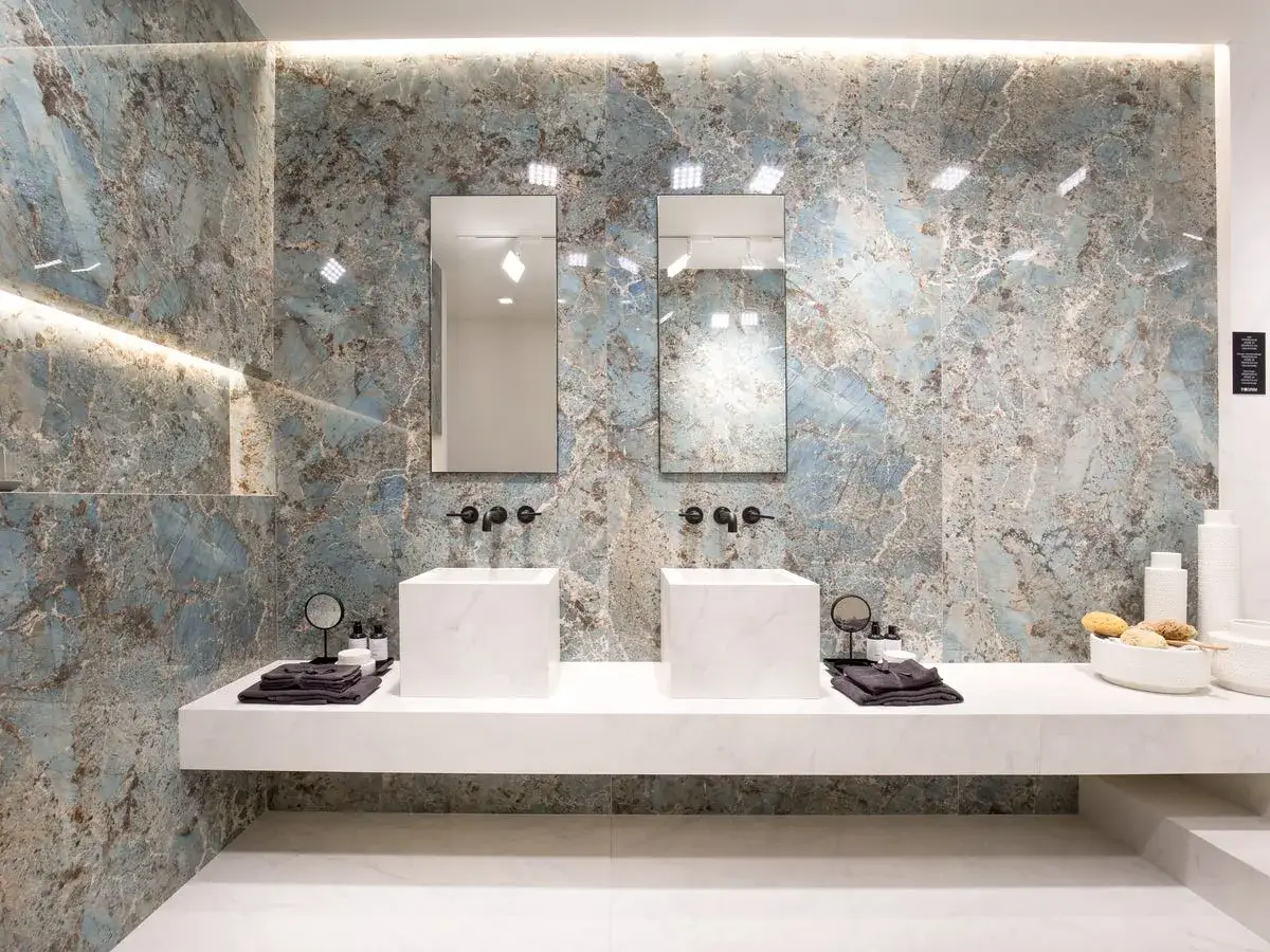 Bagno moderno con lavabi quadrati e specchi, pareti con piastrelle effetto marmo blu. Idee per dipingere piastrelle bagno con stile.