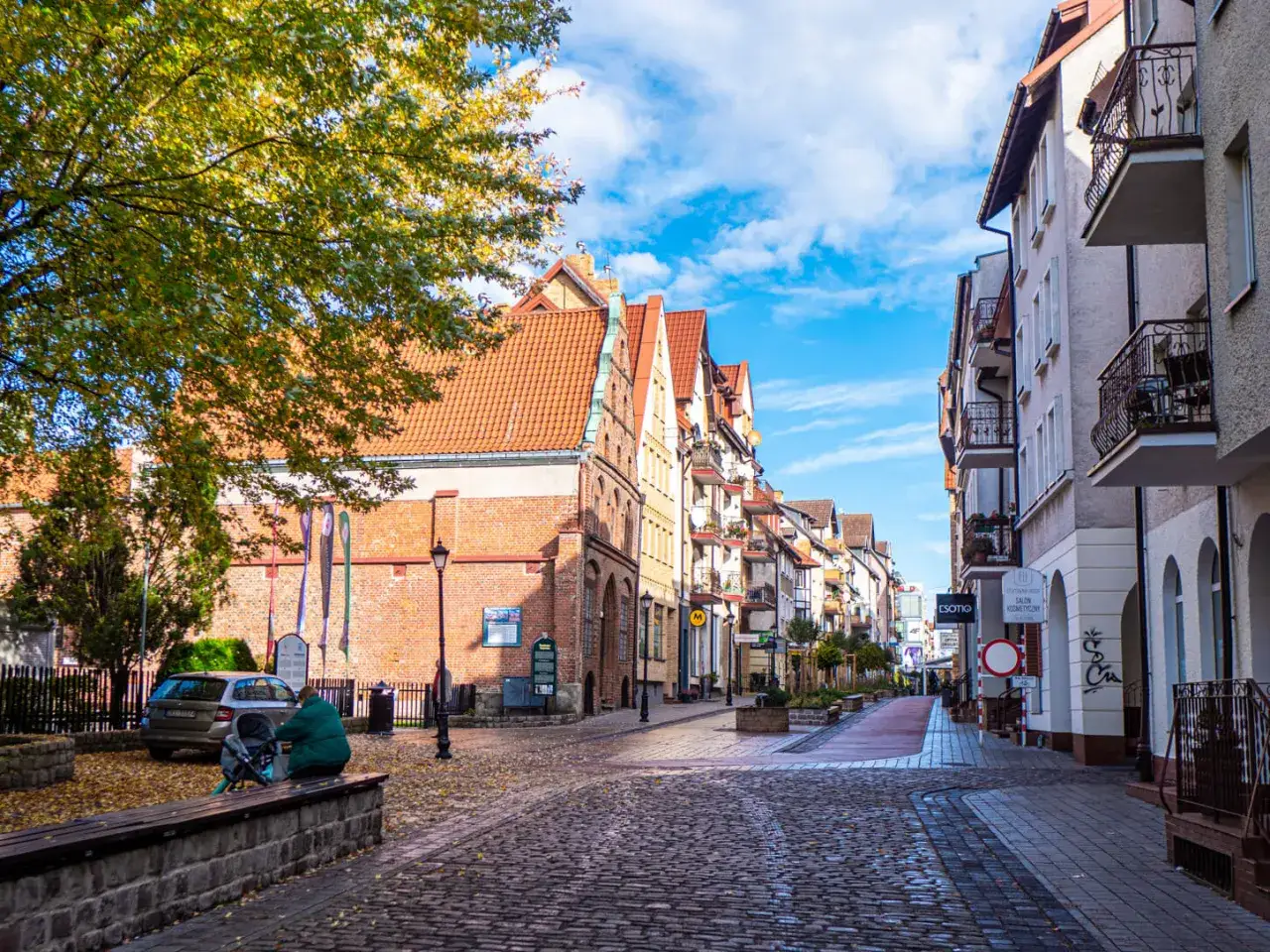 Urokliwa ulica w Kołobrzegu, z brukowaną nawierzchnią i zabytkową architekturą. Warto zobaczyć w Kołobrzegu to miejsce, idealne na spacer.
