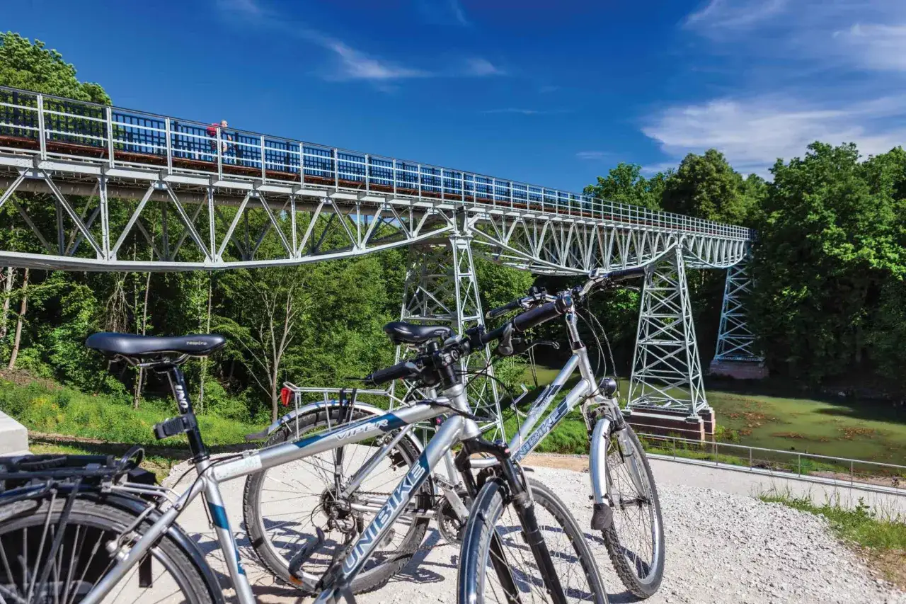 Dwa rowery czekają na odkrycie malowniczych tras rowerowych Bydgoszcz. W tle widać imponujący wiadukt kolejowy nad zieloną doliną.