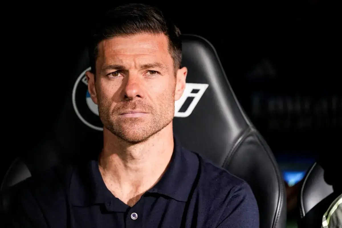 Xabi Alonso, potencjalny trener Chelsea, siedzi na ławce rezerwowych, skupiony i poważny.