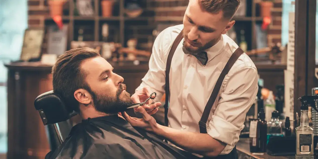 barber przycinający brodę klientowi
