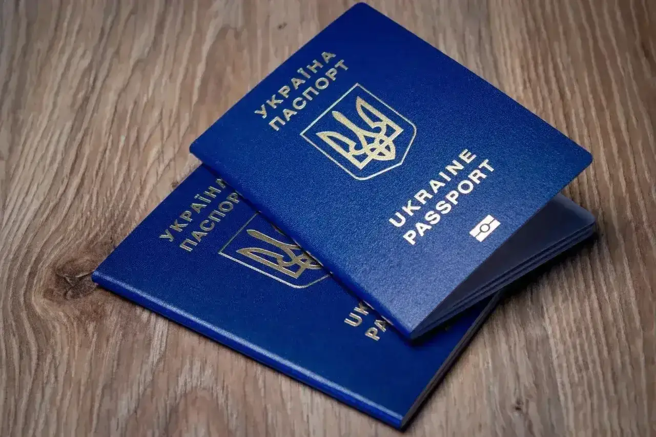 Dwa niebieskie paszporty Ukrainy leżą na drewnianym blacie. Planujesz podróż? Wiza do Turcji może być potrzebna.