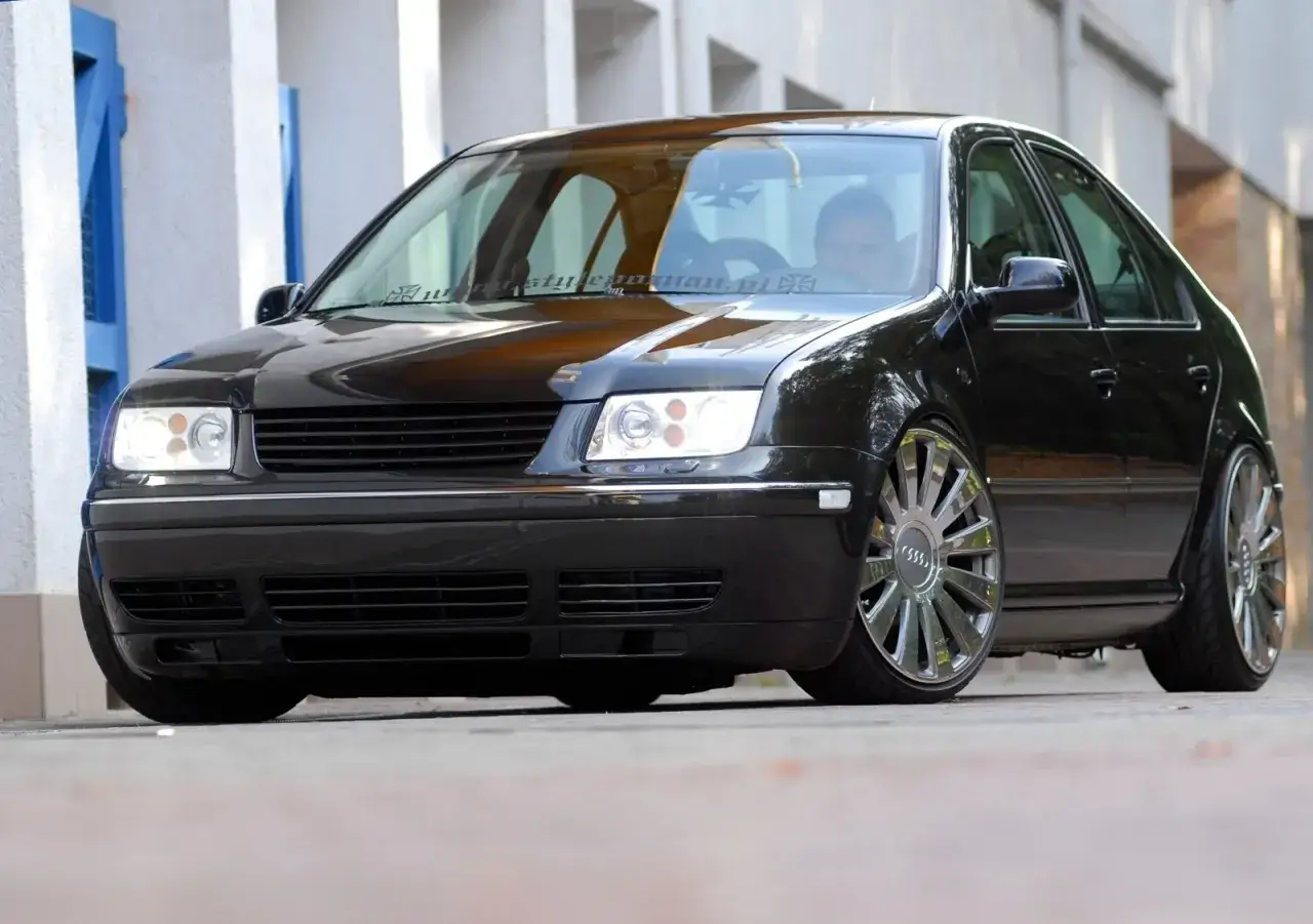 Czarna Bora z przyciemnianymi szybami i felgami Audi. Kierowca wpatrzony w drogę.