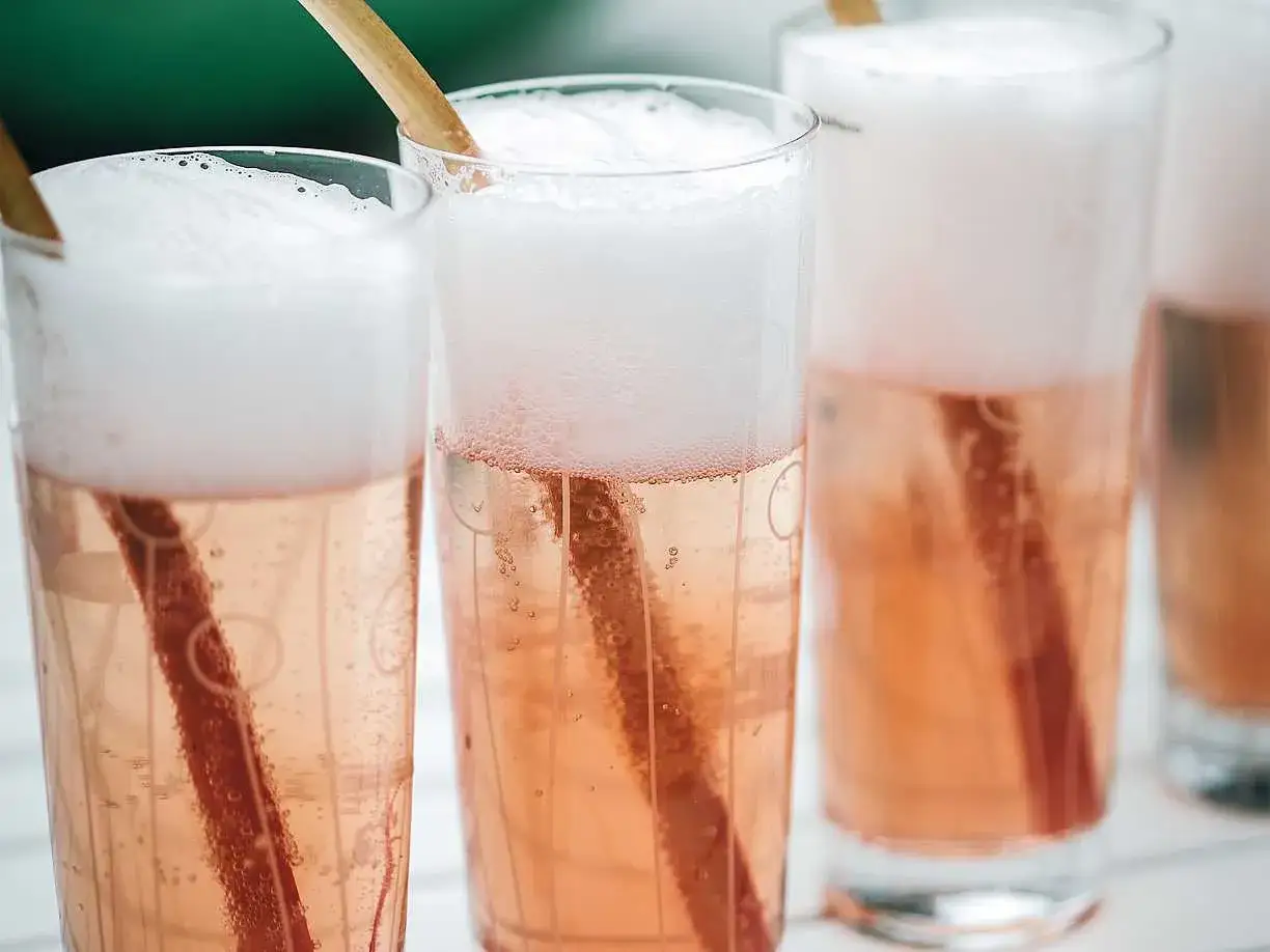 Bubblig rabarbersaft i glas med tr&auml;pinnar. Perfekt f&ouml;r ett somrigt rabarbersaft recept.