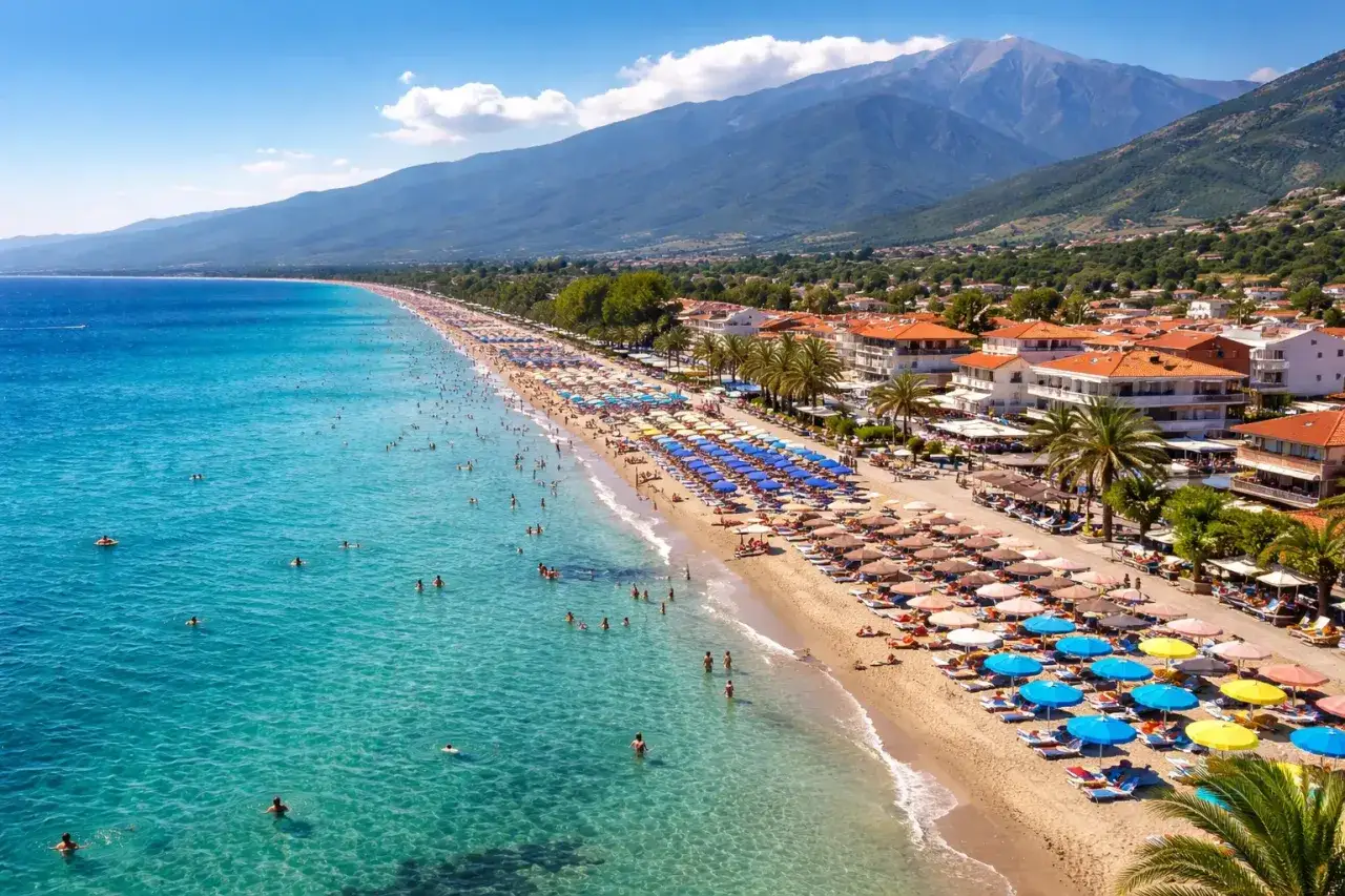 Piękna, słoneczna riwiera olimpijska. Pogoda idealna do kąpieli w krystalicznie czystej wodzie i wypoczynku na piaszczystej plaży pod kolorowymi parasolami.