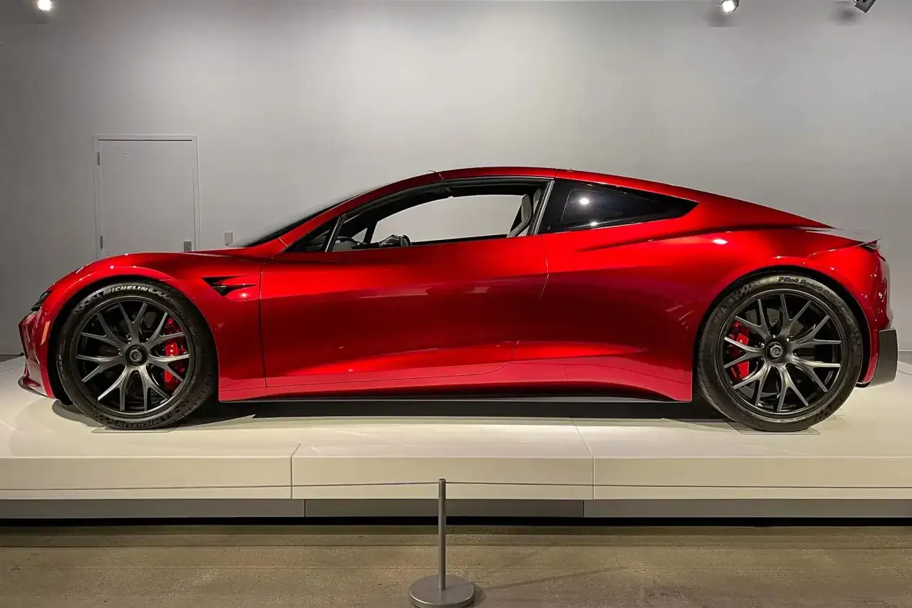 Roter Tesla Roadster, bereit für den Sprint von 0 auf 100 km/h. Sein glänzendes Design verspricht atemberaubende Leistung.