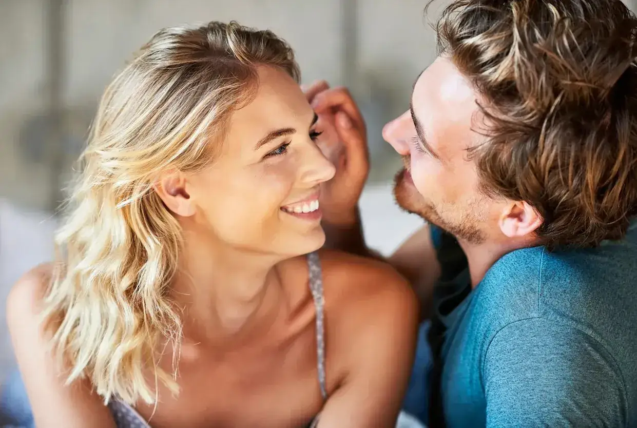 Un couple complice, elle rit aux éclats tandis qu'il lui murmure un secret. Une scène intime qui pourrait bien servir à comment rendre un homme jaloux.
