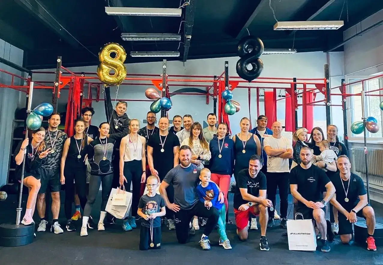 Grupa ludzi w siłowni z balonami w kształcie ósemki. Idealne miejsce, by dowiedzieć się, crossfit od czego zacząć.