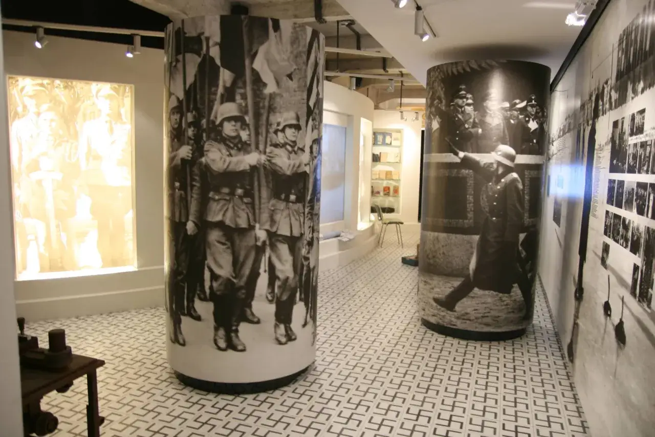 Wystawa w Muzeum Fabbrica di Schindler. Cylindry z historycznymi zdjęciami, w tym żołnierzy i przemówień.