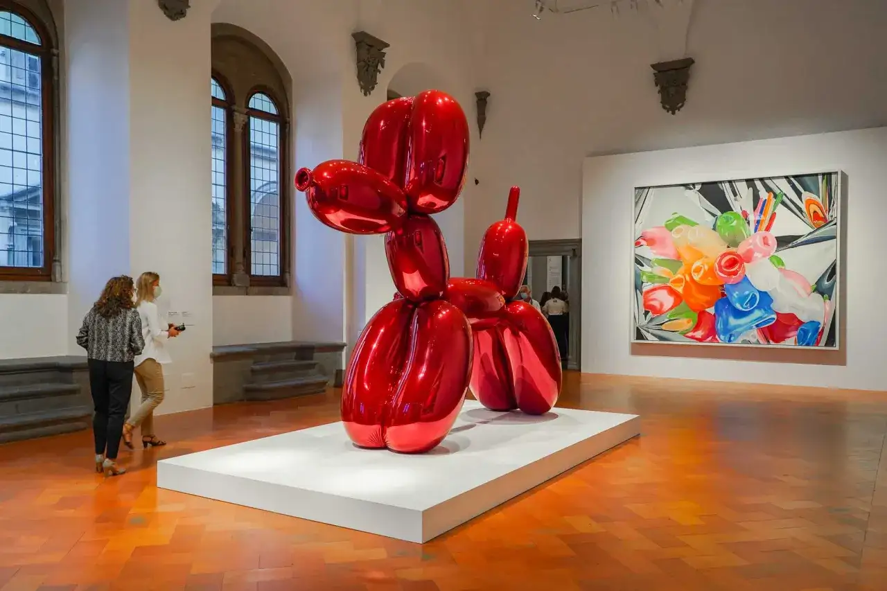 Un chien ballon rouge g&eacute;ant, &oelig;uvre embl&eacute;matique de Jeff Koons, brille dans une galerie.