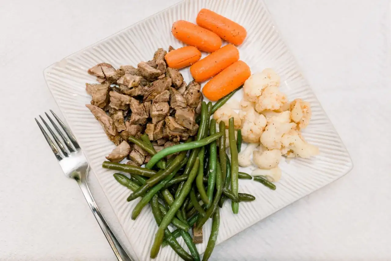 Assiette de steak, haricots verts, carottes et chou-fleur. Un repas sans sucre sain et équilibré.