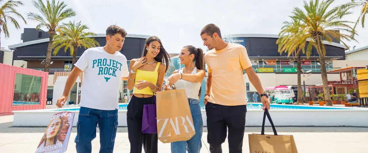Cuatro amigos disfrutan de un día de compras en el centro comercial Bonaire, cargados de bolsas de Zara y Bershka.