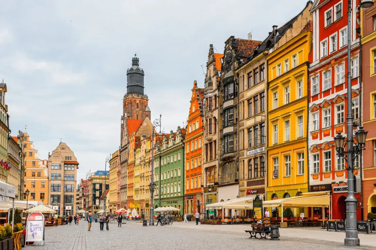 Kolorowe kamienice na wrocławskim Rynku tworzą malowniczy widok. W tle widać wieżę ratuszową.