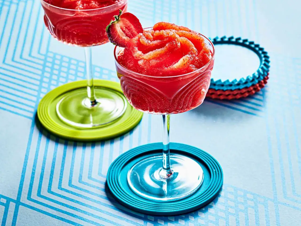 Två glas med fryst jordgubbsdaiquiri, garnerade med jordgubbe. Perfekt för ett frozen strawberry daiquiri recept.