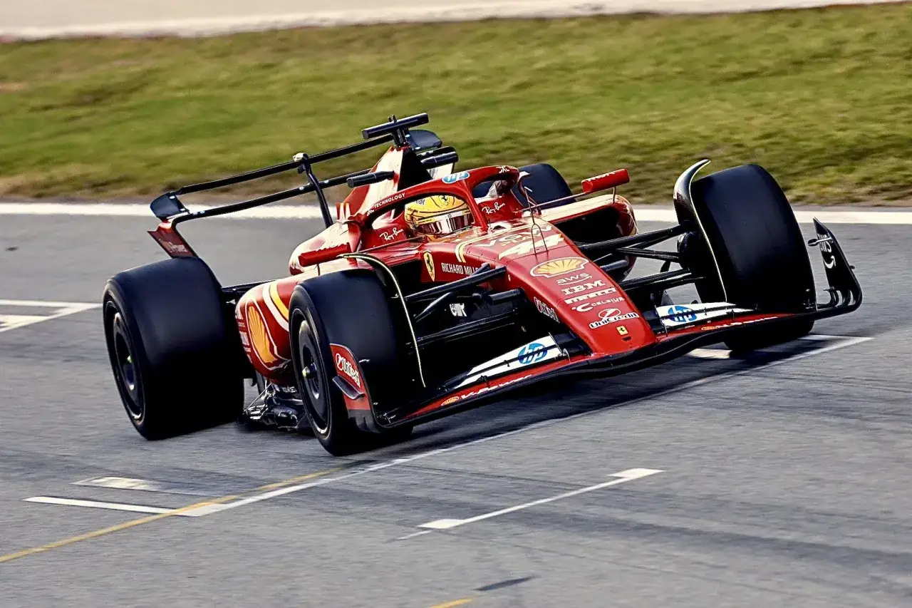 Sir Lewis Hamilton in seinem roten Ferrari-Formel-1-Auto, das mit voller Geschwindigkeit über die Rennstrecke rast.